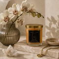 Lumânare parfumată Love Spell Jasmine Garden într-un decor elegant cu orhidee, cristale și accesorii aurii.